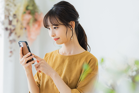 女性がスマートフォンを操作している写真